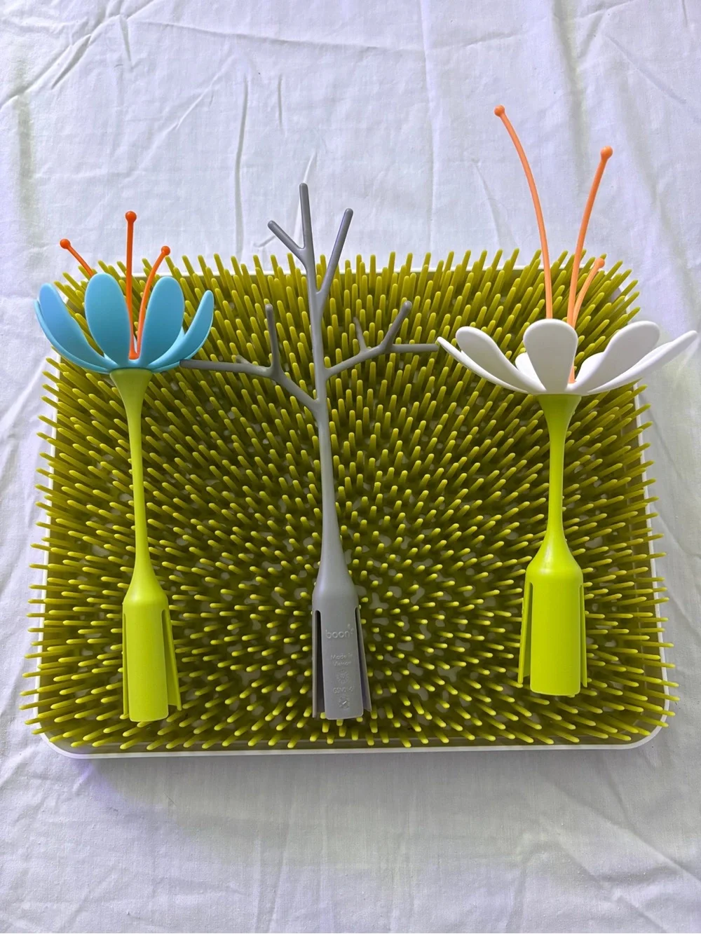 Green Grass-Style Bottle Drying Rack with Blue and White Flower Stems